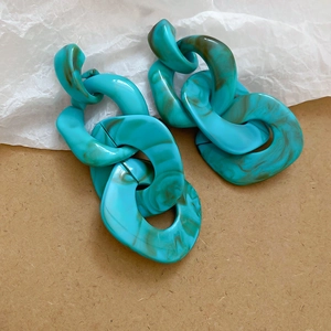 Detailed macro view of oversized turquoise marble acrylic chunky chain link earrings