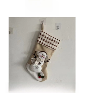 Detail of burlap Christmas stocking featuring a 3D snowman with plaid cuff decoration