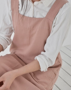 Detailed view of pink cotton linen apron on model in a cozy Japanese minimalist home setting