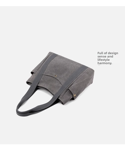 Detail of grey canvas tote bag featuring side pockets and a functional front slot