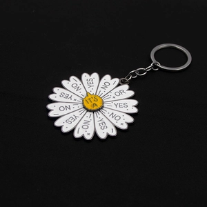 Macro detail of daisy enamel keychain with interactive yes no or spinning wheel text