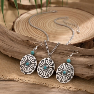 Detail of vintage silver necklace and turquoise earrings on a natural wood background