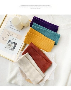 Detailed knit texture of rib-stitched fingerless arm warmers in various autumn colors