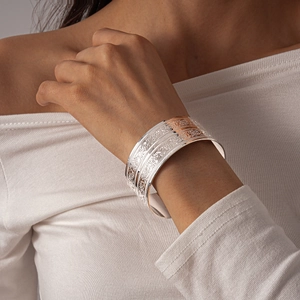 Detailed view of wide open cuff bracelet with vintage floral and scroll engravings