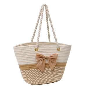 Beige woven tote bag with a brown satin bow and rope handles for summer leisure
