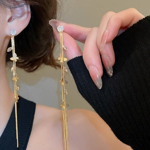 Boucles d'oreilles longues dorées à pompons avec motifs papillon et feuilles en strass