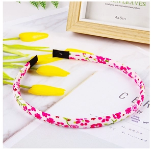 Detailed view of floral fabric headband on a decorative wooden display background