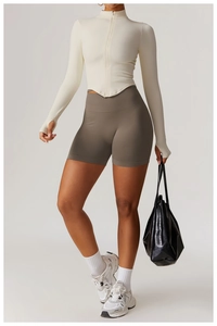 Détail du haut de sport zippé ivoire à passe-pouces et short marron sans coutures