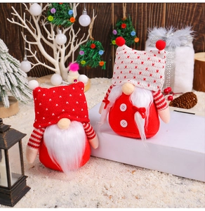 Detail of knitted faceless gnomes in a snowy Christmas scene with festive holiday decor