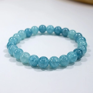 Close-up detail of blue beaded bracelet with natural crackle texture and polished stones