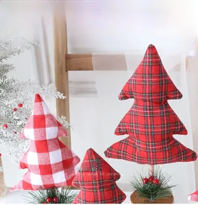 Close-up of fabric Christmas trees with plaid patterns, pine needles and wood base