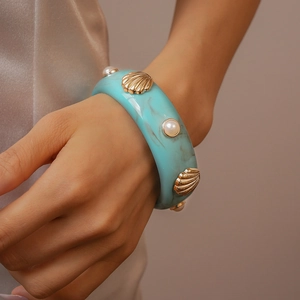 Vue détaillée du large bracelet en résine turquoise marbré avec coquillages et perles