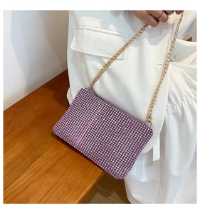 Detail of pink rhinestone envelope bag featuring luxury gold chain strap and crystal texture