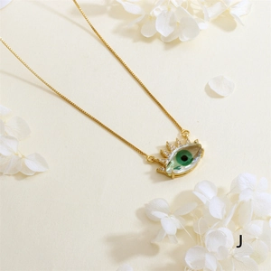 Close-up of gold plated evil eye pendant with green stone and white zircon stones