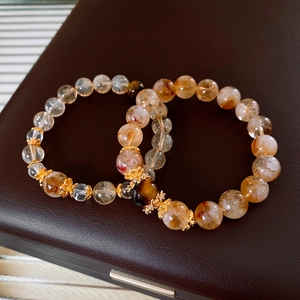 Close-up of Citrine and Tiger Eye bracelets on leather display, showcasing luxury beads
