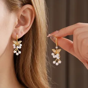 18K vergulde vlinder oorbellen met parels en kristallen gedragen door model