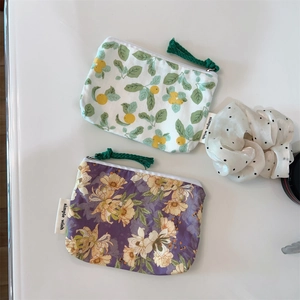 Detail view of floral cotton mini pouches with zipper tassels and brand label