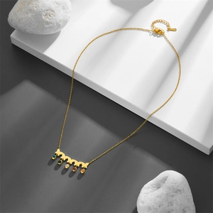 Detail of gold titanium necklace featuring butterfly charms and vibrant colored gemstones