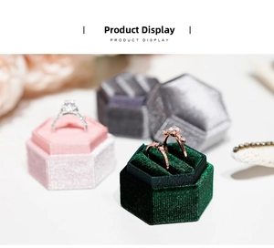 Detailed view of hexagonal velvet jewelry boxes in pink and green with rings