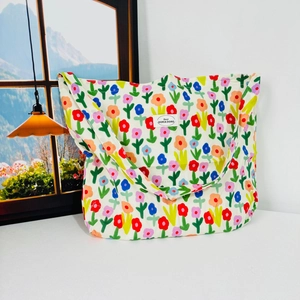 Detailed view of floral canvas tote bag with colorful hand-painted flower patterns