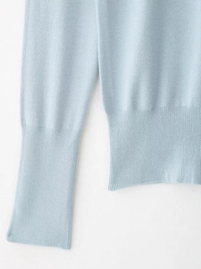 Detail of light blue knitted sweater showing high-quality ribbed cuffs and hem texture