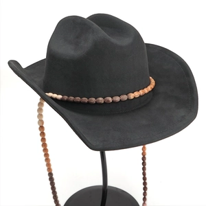 Détail d'un chapeau de cow-boy en daim noir avec perles ethniques et glands bohèmes