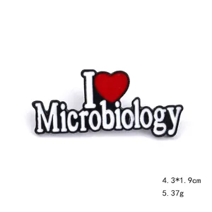 Detailed view of enamel brooch measuring 4.3x1.9cm with I Love Microbiology text