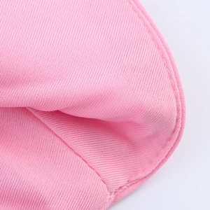 Macro detail of pink knitted fabric showing fine texture and reinforced curved stitching