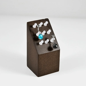 Macro view of blue and black belly rings displayed on a premium dark wood exhibition stand