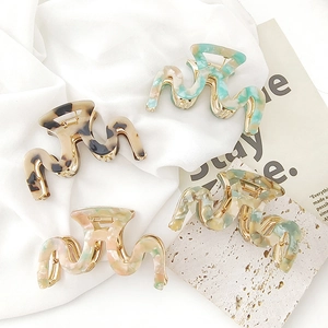 Set of four wave-shaped acetate hair claws with marble and tortoiseshell patterns