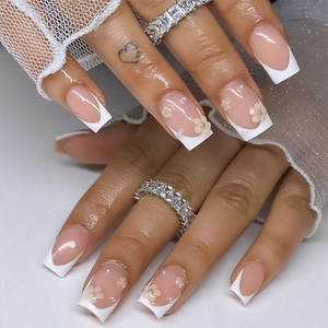 Detail of French square press-on nails with white 3D flowers and pearl accents