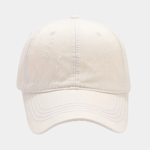 Detail of washed beige baseball cap featuring distressed fabric and stitched seams
