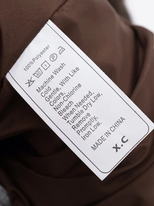 Gros plan de l'étiquette 100% polyester avec instructions de lavage sur la veste en fausse fourrure