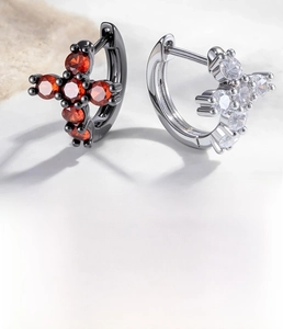 Macro detail of cross pendant hoop earrings with zircon stones and snap closure