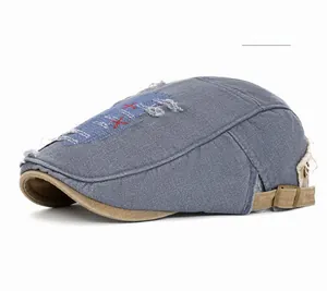 Détail de la casquette gavroche en jean bleu avec broderie et sangle réglable
