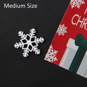 Macro detail of silver snowflake charms with purple glitter for Christmas DIY crafts