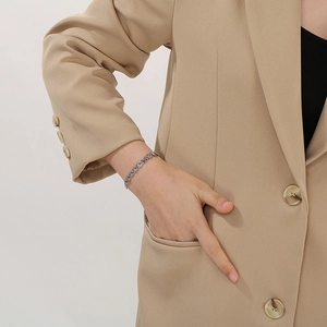 Detailed close-up of a silver chain bracelet on a wrist with minimalist fashion styling