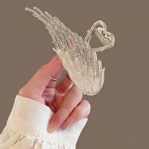 Macro view of gold angel wing hair claw clip with cat eye stones and sparkling rhinestones
