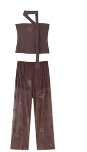 Vue détaillée des paillettes marron foncé et des motifs étoilés sur l'ensemble large