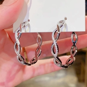 Silver twisted hoop earrings with delicate zircon inlay shown on a white card