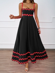 Detail of red zigzag embroidery on the neckline of a black summer maxi dress