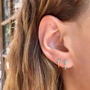 Close-up of gold S925 silver hoop earrings featuring turquoise cross and marquise stones