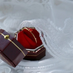 Detailed shot of 18k gold thin ring with red gemstone in a luxury velvet jewelry box