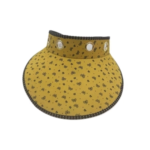 Close-up of yellow sun visor featuring floral pattern and polka dot brim details