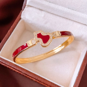 Macro shot of gold-plated wulu bangle with red enamel and pavé crystals in a jewelry box