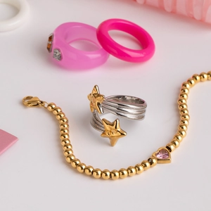 Vue détaillée d'une bague étoile argentée et d'un bracelet doré avec pendentif cœur