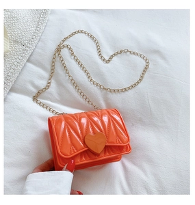 Detail of orange heart-shaped buckle and wavy texture on glossy silicone chain bag