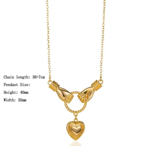 Detail view of 18K gold hand pendant necklace with 38+7cm chain and heart charm