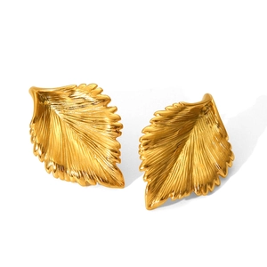 Macro detail of golden leaf stud earrings with realistic vein texture on stainless steel