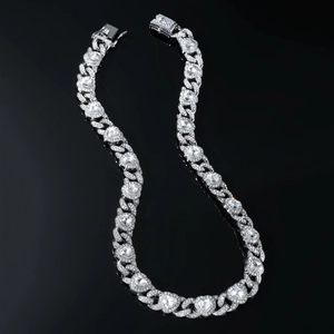 Macro shot of silver hip hop Cuban chain featuring heart and round crystal pavé settings